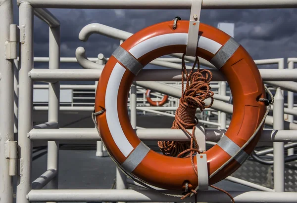 Orange lifebuoy attached to a railing of a pier — Stock Photo, Image