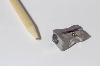 Metal bileyicili kırık kalem, kırık kurşun çubuk ve beyaz kağıtta talaş.