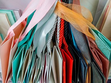  Tezgahta çok renkli ambalaj kağıtları, kurdeleli kağıt torbaları.