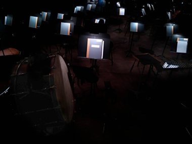 Orkestra çukurunda bir bale, opera ve sandalyelerin açık notalarıyla müzik standları 