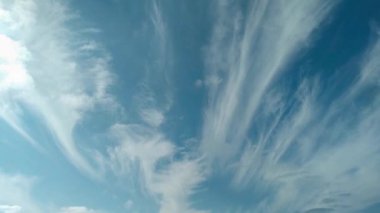 white cirrus-layered clouds in a blue sky can be used as background, time lapse