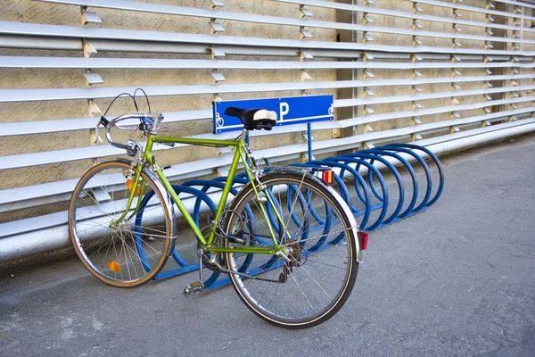 Um estacionamento de bicicleta no estacionamento contra uma parede — Fotografia de Stock