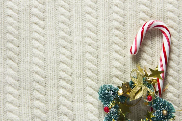 Knitted wool texture with christmas decoration, candy cane or cup of tea — Stock Photo, Image
