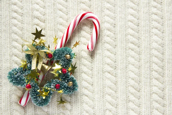 Knitted wool texture with christmas decoration, candy cane or cup of tea — Stock Photo, Image