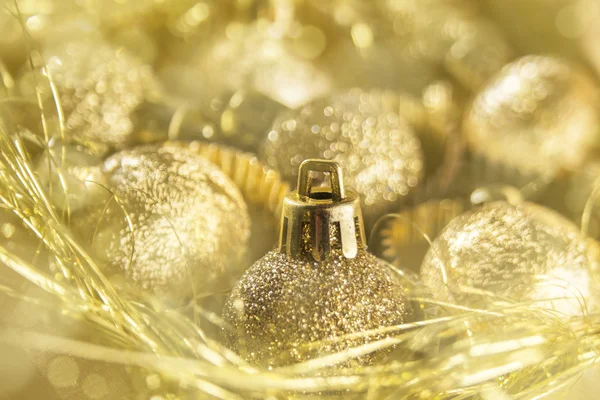 Natal dourado bugigangas e ouropel e fundo bokeh — Fotografia de Stock