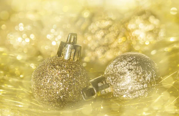 Golden Christmas baubles and tinsel and bokeh background — Stock Photo, Image