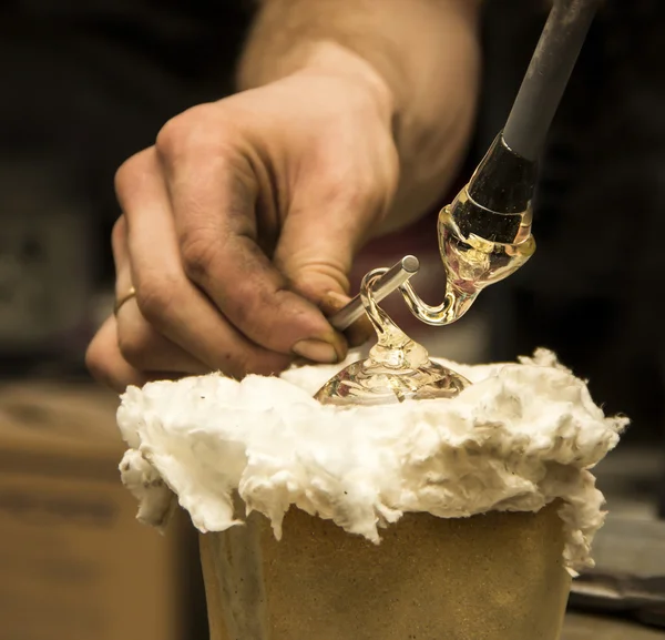 Handgemaakte figuur van gesmolten glas, een glas blower gesmolten glas bezig met een staaf — Stockfoto