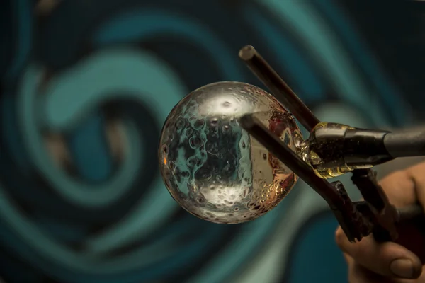 Handmade figure of melted glass, a glass blower working molten glass on a rod — Stock Photo, Image