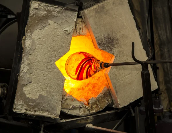 Handmade figure of melted glass, a glass blower working molten glass on a rod — Stock Photo, Image