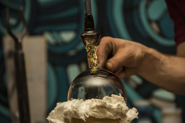 Handmade figure of melted glass, a glass blower working molten glass on a rod — Stock Photo, Image