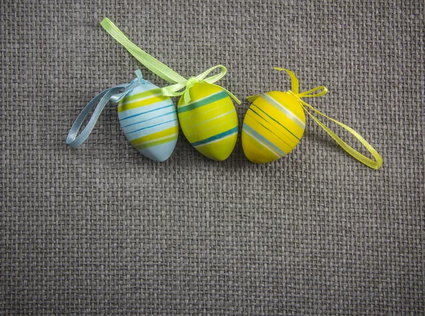 Easter eggs with ribbons on grey wicker background — Stock Photo, Image