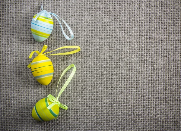 Easter eggs with ribbons on grey wicker background — Stock Photo, Image