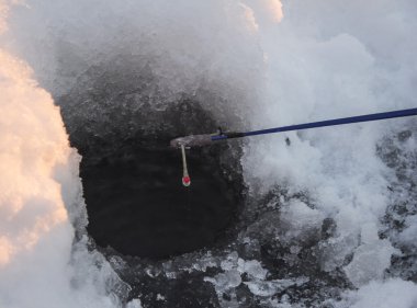 Kış balıkçılığı için buz deliği ve olta.