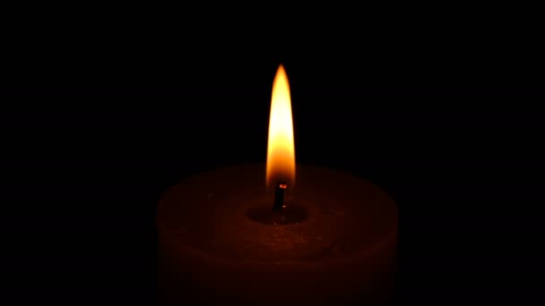 浓密的纪念蜡烛在黑色背景上以4K分辨率视频剪辑的形式燃烧和旋转 — 图库视频影像