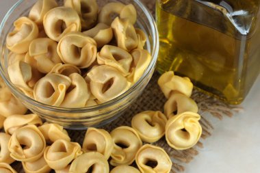 Çiğ tortellini peynirli geleneksel İtalyan hamur tatlısı masanın üzerinde yakın plan makro fotoğrafçılık yatıyor.