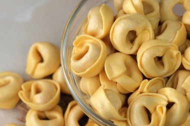 Çiğ tortellini peynirli geleneksel İtalyan hamur tatlısı masanın üzerinde yakın plan makro fotoğrafçılık yatıyor.