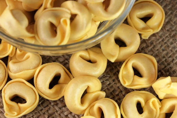 Çiğ tortellini peynirli geleneksel İtalyan hamur tatlısı masanın üzerinde yakın plan makro fotoğrafçılık yatıyor.