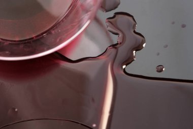 Bir bardak kırmızı şarap siyah yüzeye döküldü. Yakın çekim makro fotoğraf.