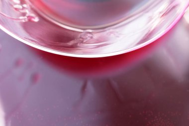 Bir bardak kırmızı şarap siyah yüzeye döküldü. Yakın çekim makro fotoğraf.