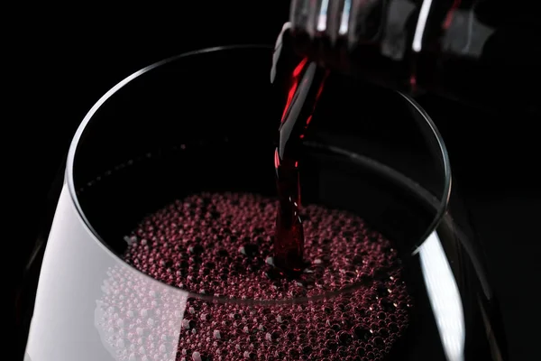 Trockener Rotwein Wird Aus Einer Flasche Auf Schwarzer Oberfläche Ein — Stockfoto