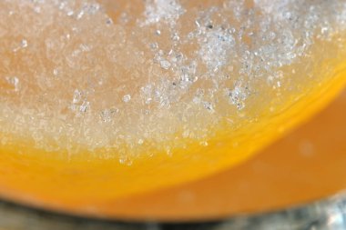 Limon dilimleri ve cam bir limonata bardağında beyaz şekerle kaplanmış makro fotoğraf.