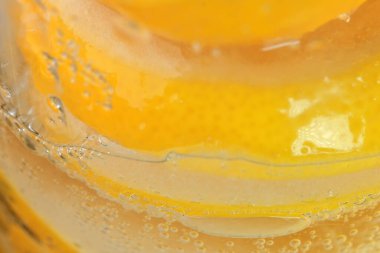 Limon dilimleri ve cam bir limonata bardağında beyaz şekerle kaplanmış makro fotoğraf.