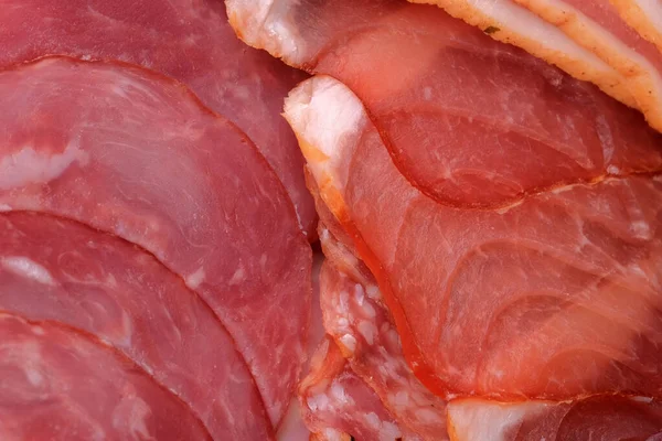 薄いスライスにスライスされた生のスモークソーセージ食料品の肉の背景クローズアップマクロ写真 — ストック写真