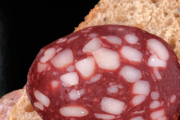 Ein Sandwich Mit Roher Räucherwurst Auf Schwarzem Hintergrund Großaufnahme — Stockfoto