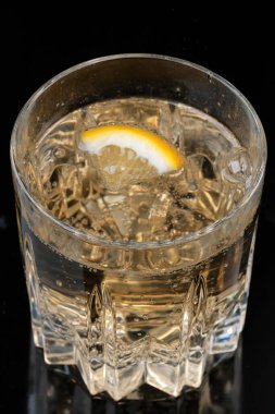 Limonata, şeffaf kristal bir cam kaplama makro fotoğrafta limon ile içilir.