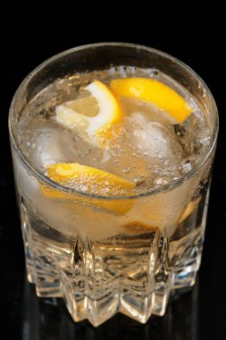 Limonata, limon ve buz dilimleri ile şeffaf kristal cam yakın çekim makro fotoğraf.