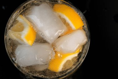 Limonata, limon ve buz dilimleri ile şeffaf kristal cam yakın çekim makro fotoğraf.