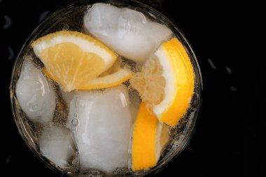 Limonata, limon ve buz dilimleri ile şeffaf kristal cam yakın çekim makro fotoğraf.