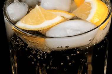 Limonata, limon ve buz dilimleri ile şeffaf kristal cam yakın çekim makro fotoğraf.