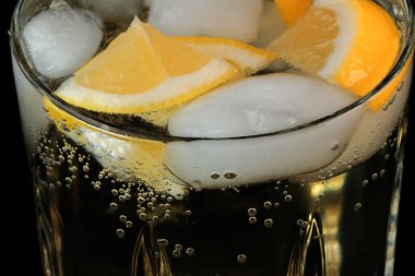 Limonata, limon ve buz dilimleri ile şeffaf kristal cam yakın çekim makro fotoğraf.