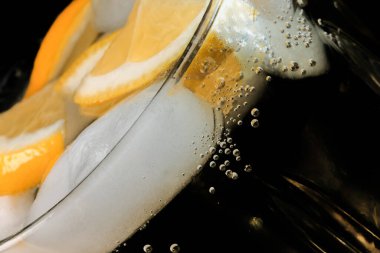 Limonata, limon ve buz dilimleri ile şeffaf kristal cam yakın çekim makro fotoğraf.