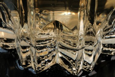 Limonata, limon ve buz dilimleri ile şeffaf kristal cam yakın çekim makro fotoğraf.