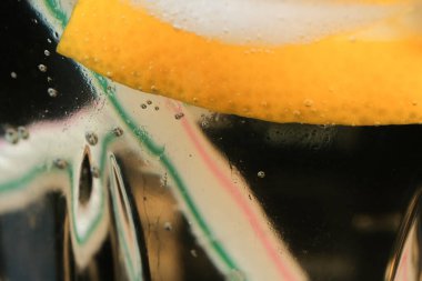 Limonata, limon ve buz dilimleri ile şeffaf kristal cam yakın çekim makro fotoğraf.