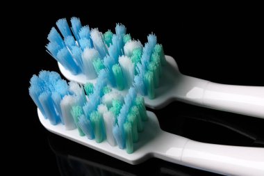 Siyah aynalı arka planda iki yeni diş fırçası yakın plan makro fotoğraf.