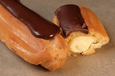 Choux pastası, tereyağı kremalı ve parşömen kağıdına çikolata kremalı. Makro fotoğraf.