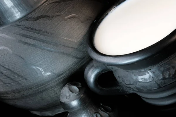 在黑色底片宏观摄影中 用黑色黏土碗中新鲜的巴氏杀菌牛奶 — 图库照片