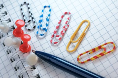 Ofis, bilimsel çalışma ve eğitimin sembolik illüstrasyonu ataçlar ve tükenmez kalem makro fotoğraflarıyla açık not defteri