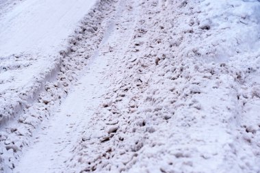 Kışın karla kaplı buzlu yolda karla kaplı kapalı bulutlu bir gün.