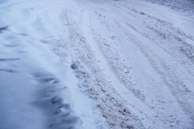 Kışın karla kaplı buzlu yolda karla kaplı kapalı bulutlu bir gün.
