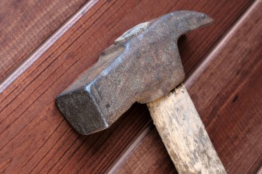 Eski paslı çekiç, son yüzyılın çivi tabancasıyla yakın plan kahverengi arka plan makro fotoğrafçılığı.