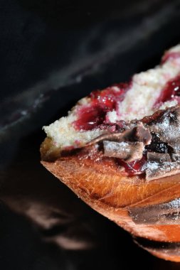 Çikolata kremalı vişneli turta üzerine pudra şekeri serpiştirilmiş, yakın plan makro fotoğraf.