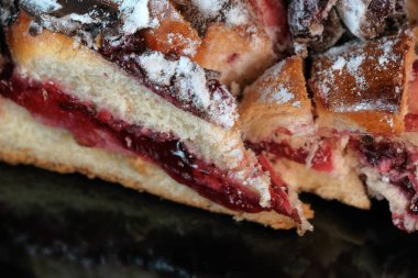 Çikolata kremalı vişneli turta üzerine pudra şekeri serpiştirilmiş, yakın plan makro fotoğraf.