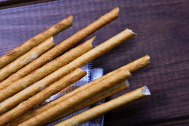 Tatlı aperatif fırınlanmış hamur çubukları ve yakın planda tuz kristalleri.