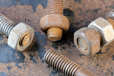 Paslı demir cıvataları ve paslı demir yüzeyinde fındıkları olan sanatsal resim. Yakın çekim makro fotoğraf.