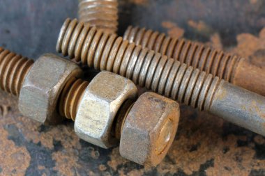 Paslı demir cıvataları ve paslı demir yüzeyinde fındıkları olan sanatsal resim. Yakın çekim makro fotoğraf.