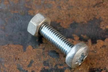 Paslı demir cıvatalı sanatsal resim ve paslı demir yüzeyde fındık yakın çekim makro fotoğraf.